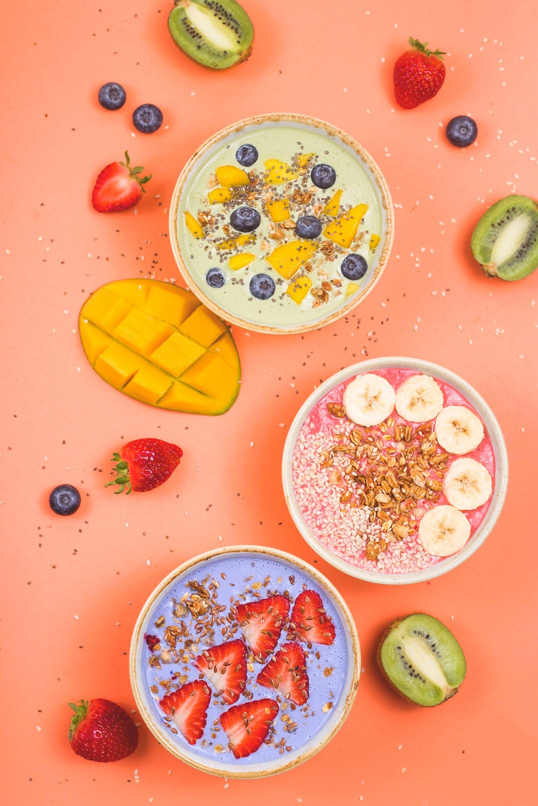 Vegetarian healthy food made from multi-colored smoothies with matches and berries on a bright pink background.