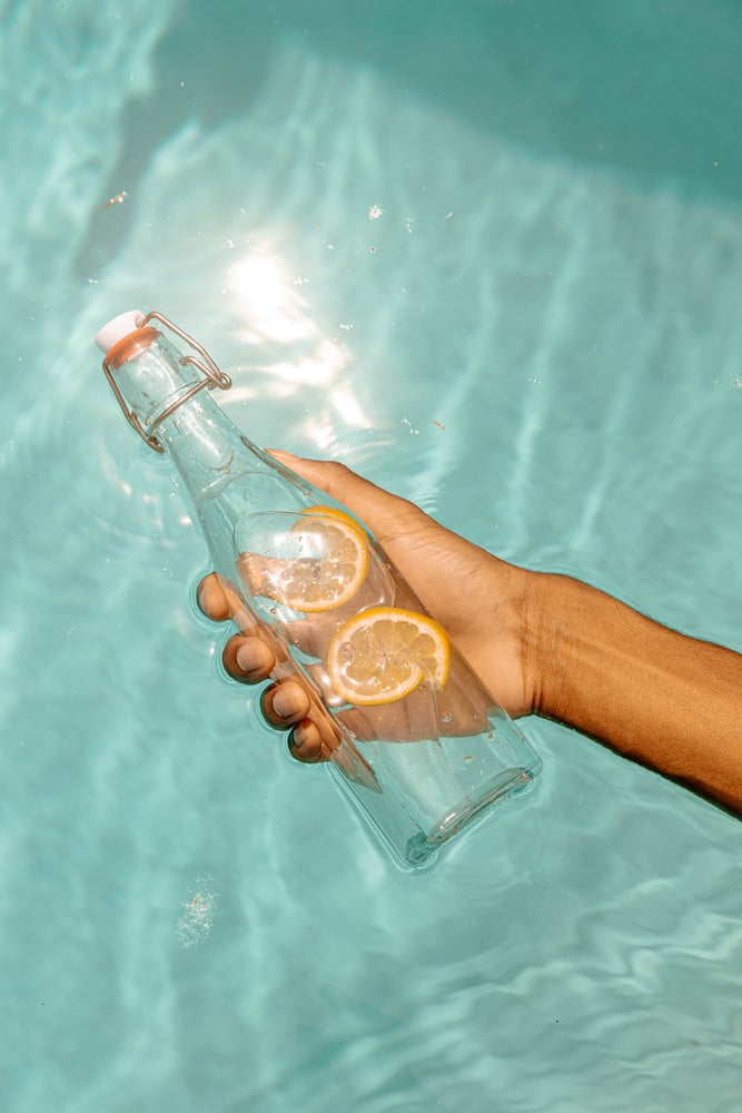 Hand Holding a Bottle of Lemon Water